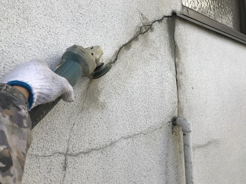 外壁のひび割れを表面だけ塞がず、必要な処理を行ったうえで修繕している様子